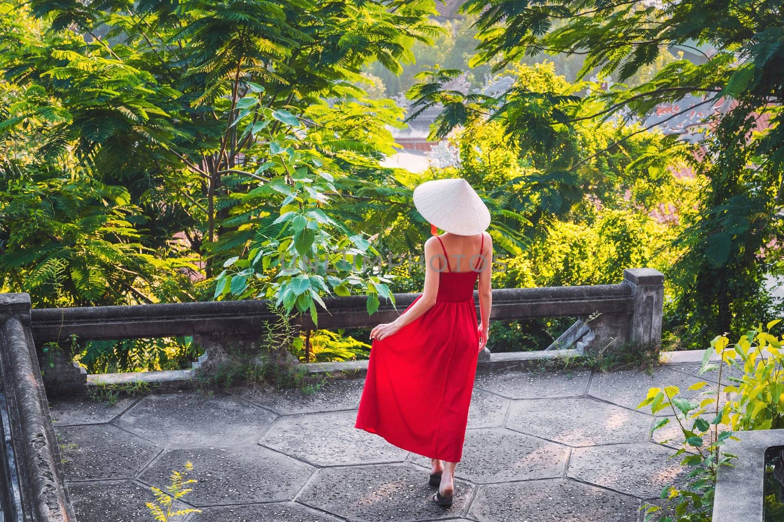 back of a young woman tourist in traditional Vietnamese hat Non La in Vietnam on a travel to Asia