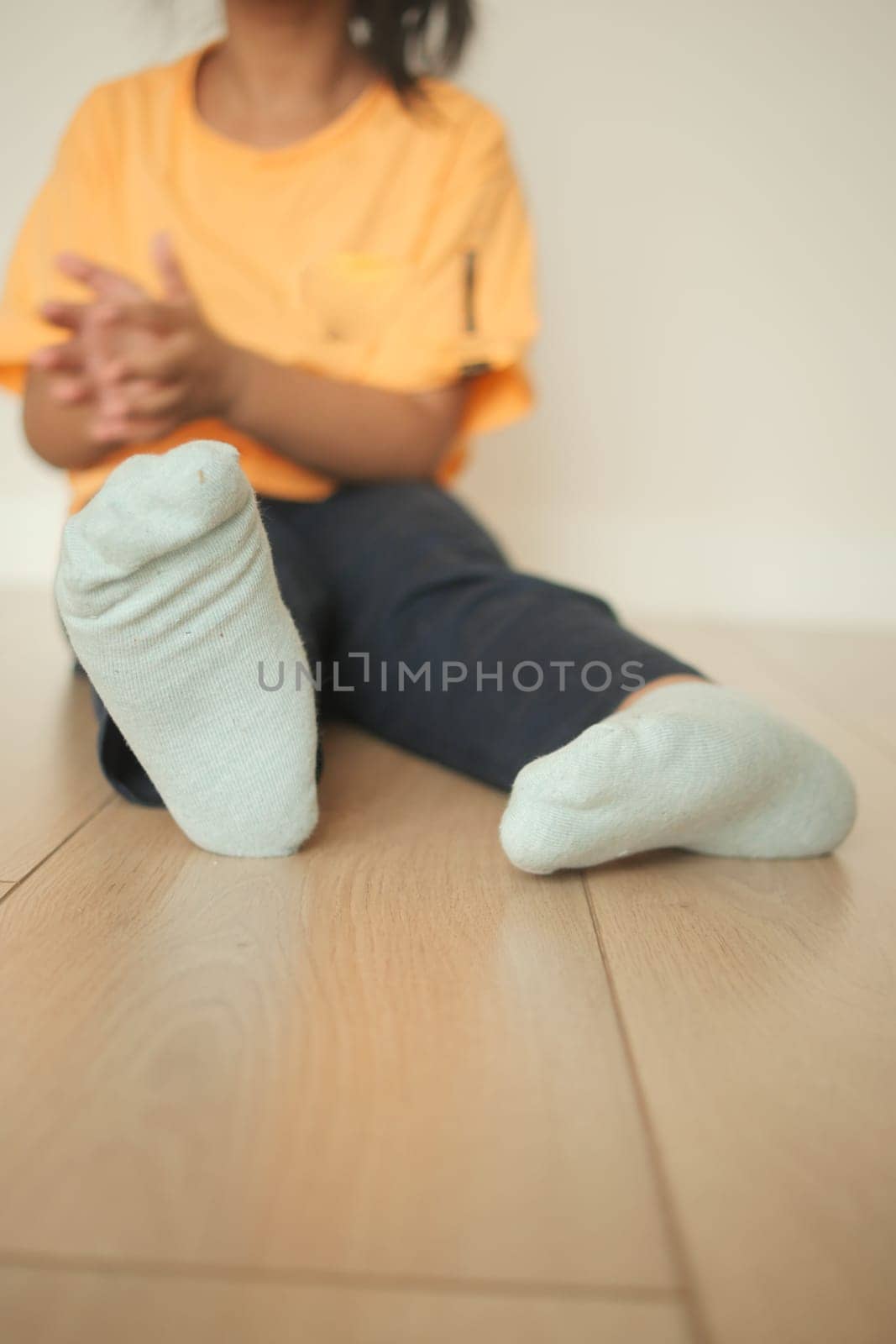 A child enjoys a moment of quiet while seated on the floor.