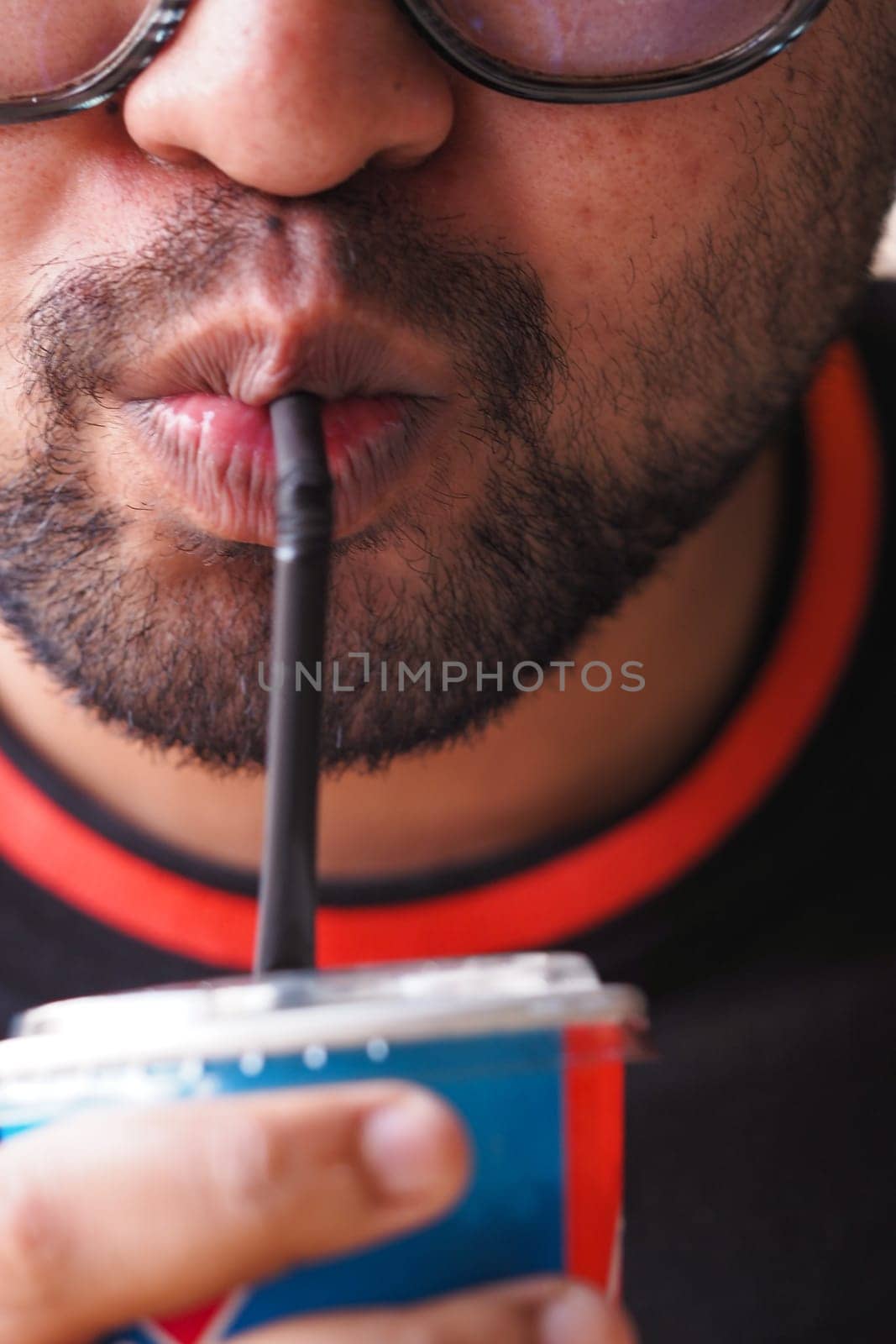 A person sipping a refreshing beverage using a straw, enjoying the moment.