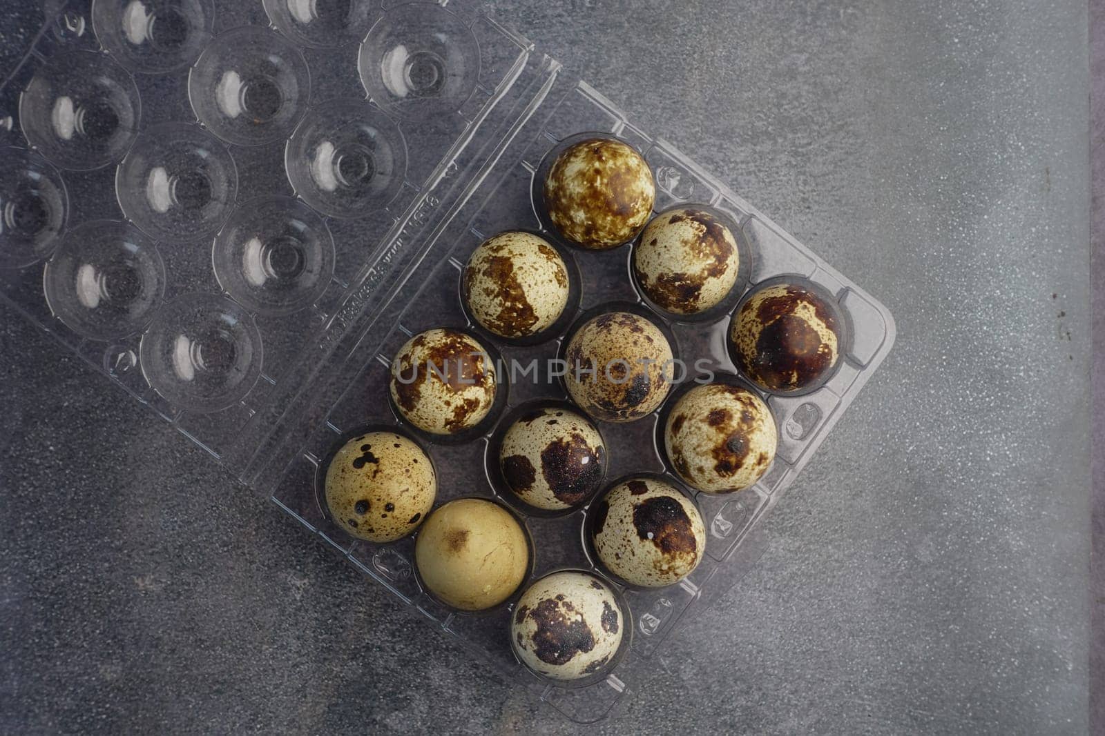 Twelve quail eggs in a clear carton, ready for meals.
