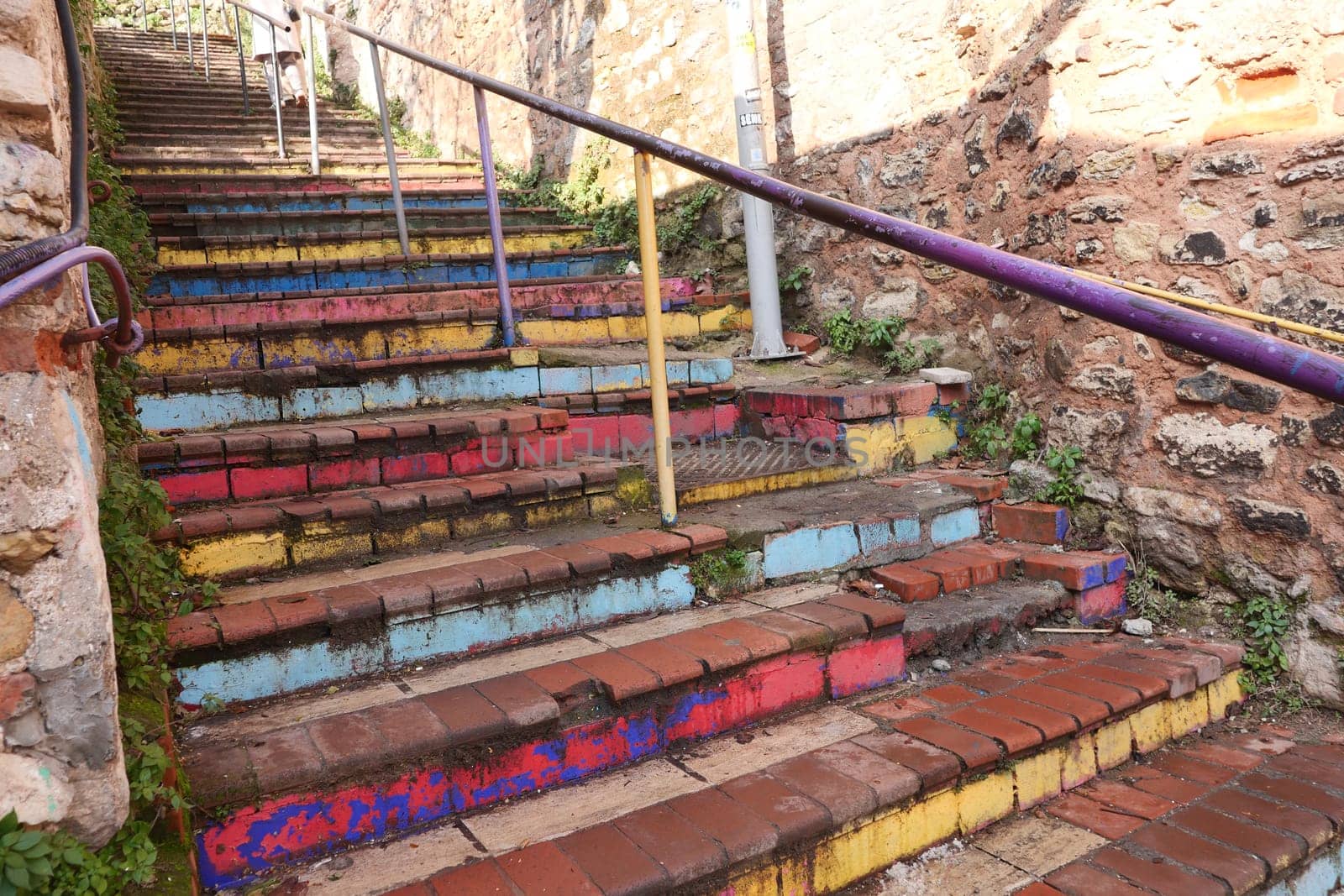 A colorful staircase with painted steps showcases artistry in an old area.