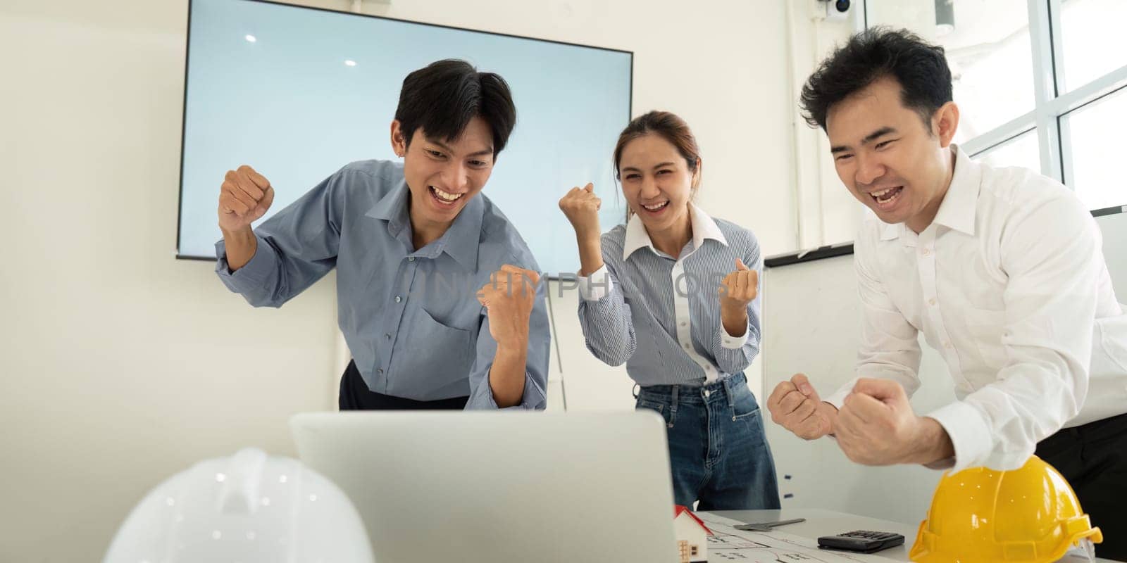 The team celebrates their recent project milestone, expressing enthusiasm and teamwork. Their shared joy highlights a collaborative success in architecture and engineering.
