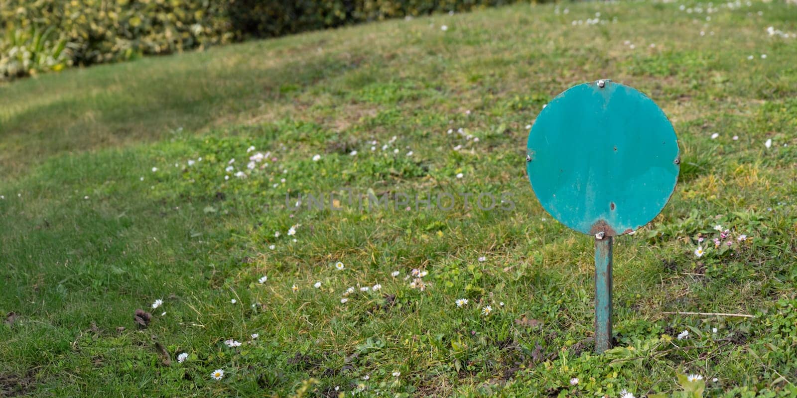 Blank information sign board mounted on lawn green grass in city park outside in sunny weather, horizontal banner with a copy space, high quality