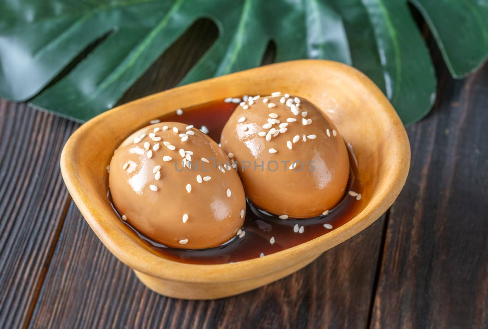 Soft-boiled ramen eggs soaked in savory marinade, garnished with sesame seeds