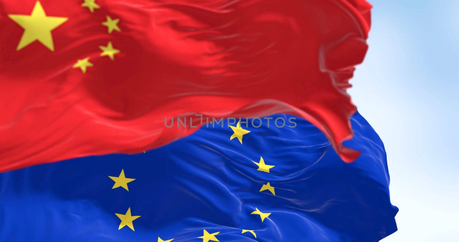 Flags of China and the European Union waving in the wind on a clear day. International relationship. 3d illustration render. Selective focus. Close-up