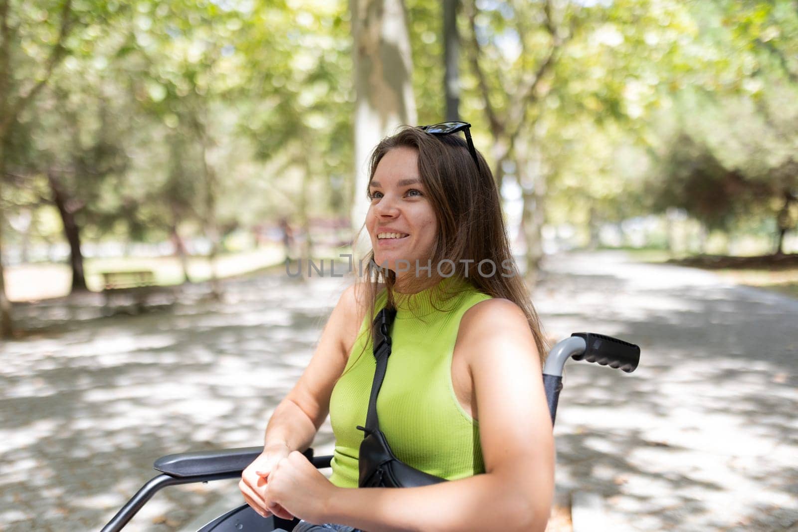 Happy disabled woman enjoying freedom and mobility in a natural park setting, embracing a positive and fulfilling life