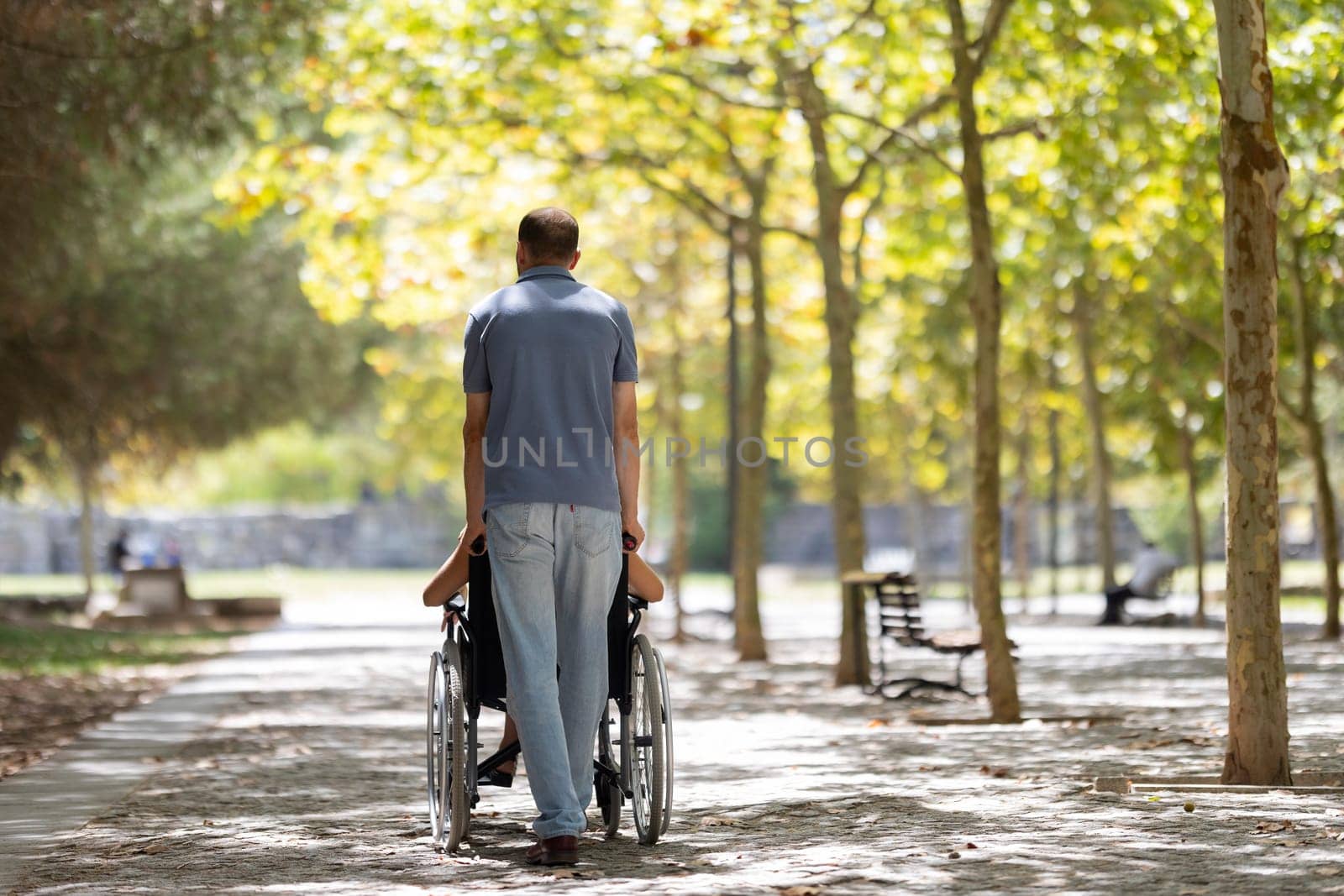 Nurse assisting a senior woman in a wheelchair, enjoying a sunny day in the park