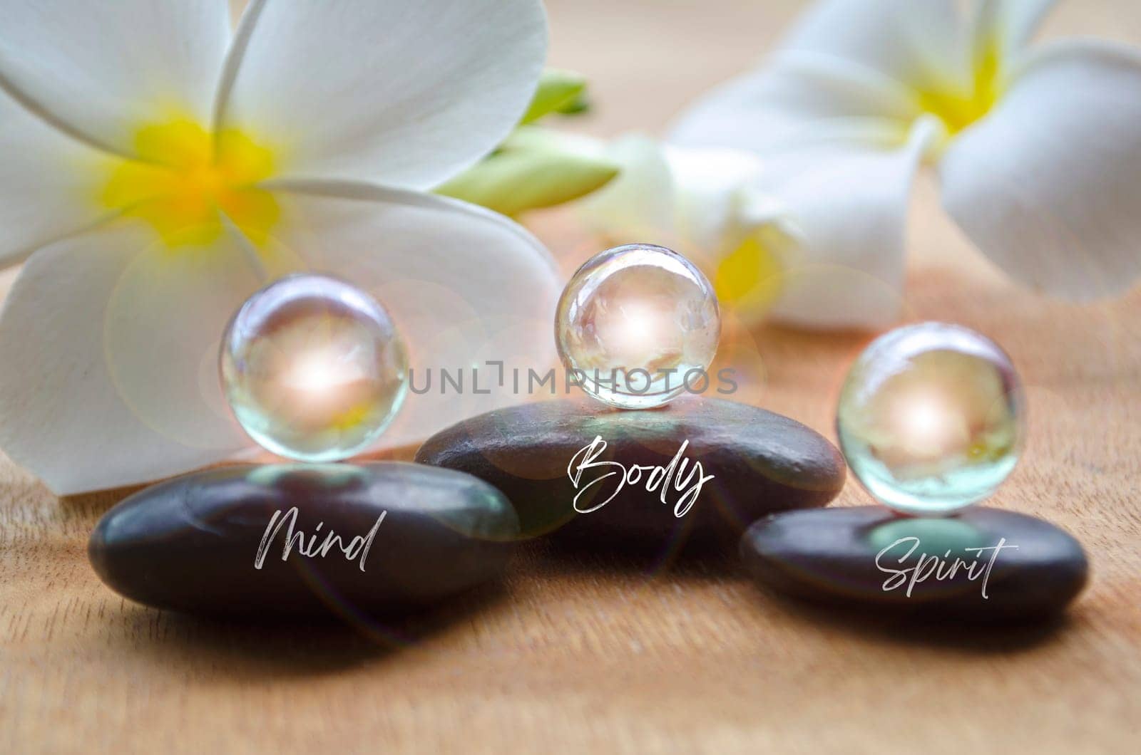 Mind, Body and Spirit text on black zen stones with shining marbles. Inner peace concept.