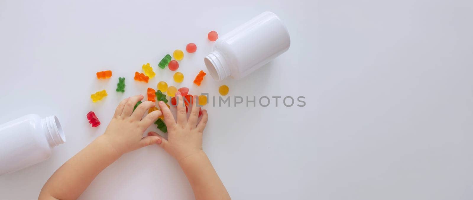 close-up of a little girl's hand taking jelly beans or vitamins