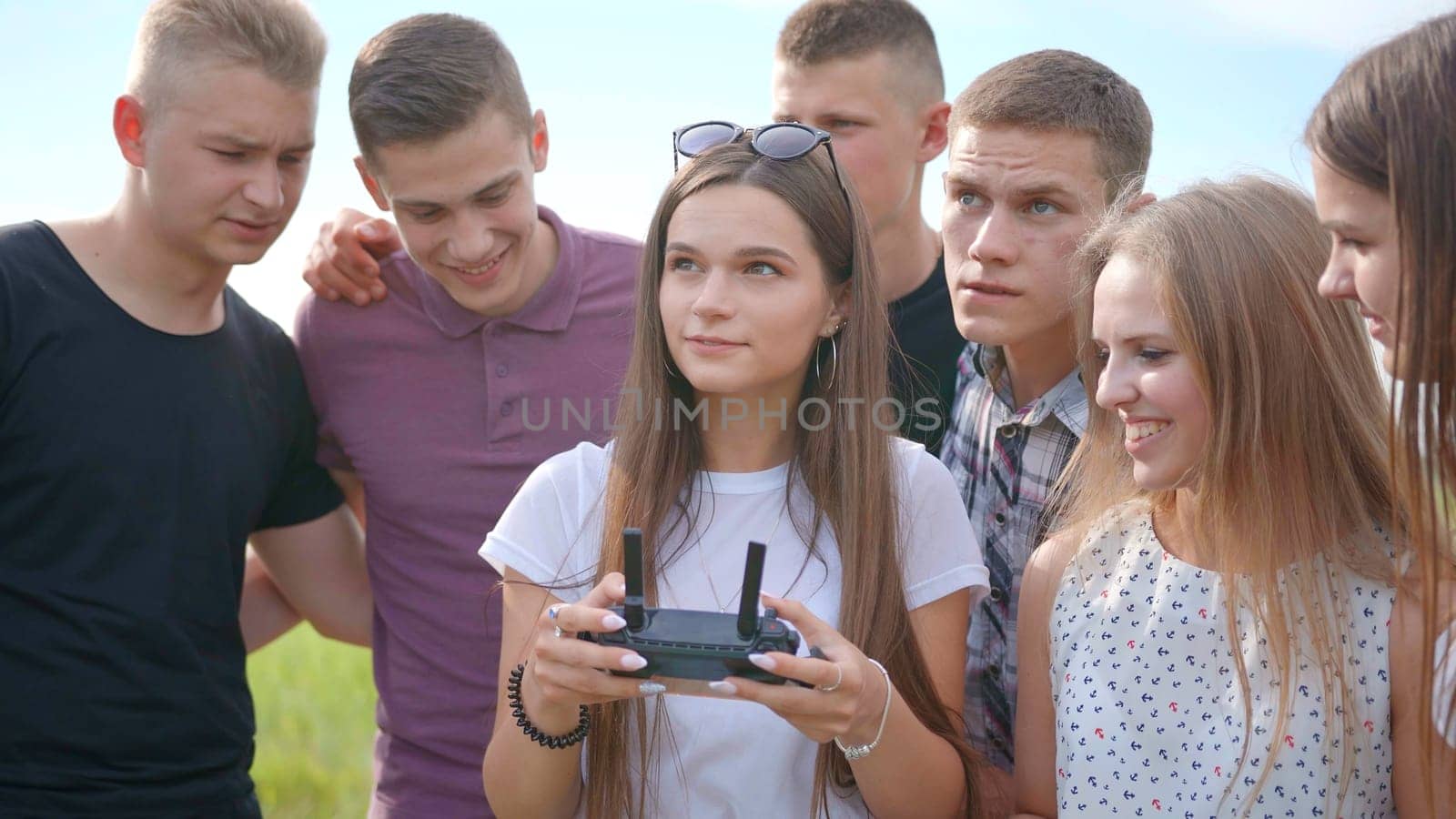 Cheerful friends control the drone using the remote control