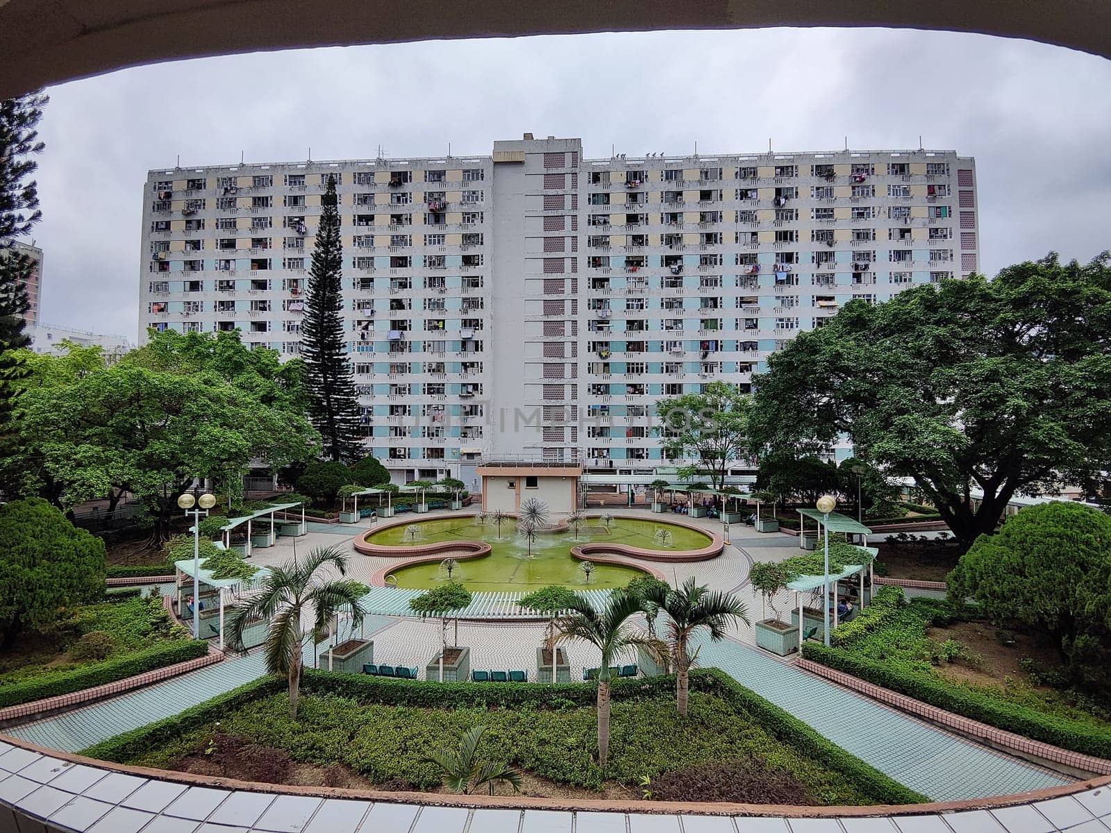 Hong Kong, China - April 06, 2024: Residents enjoy a peaceful garden area surrounded by tall buildings and vibrant foliage in central Hong Kong.
