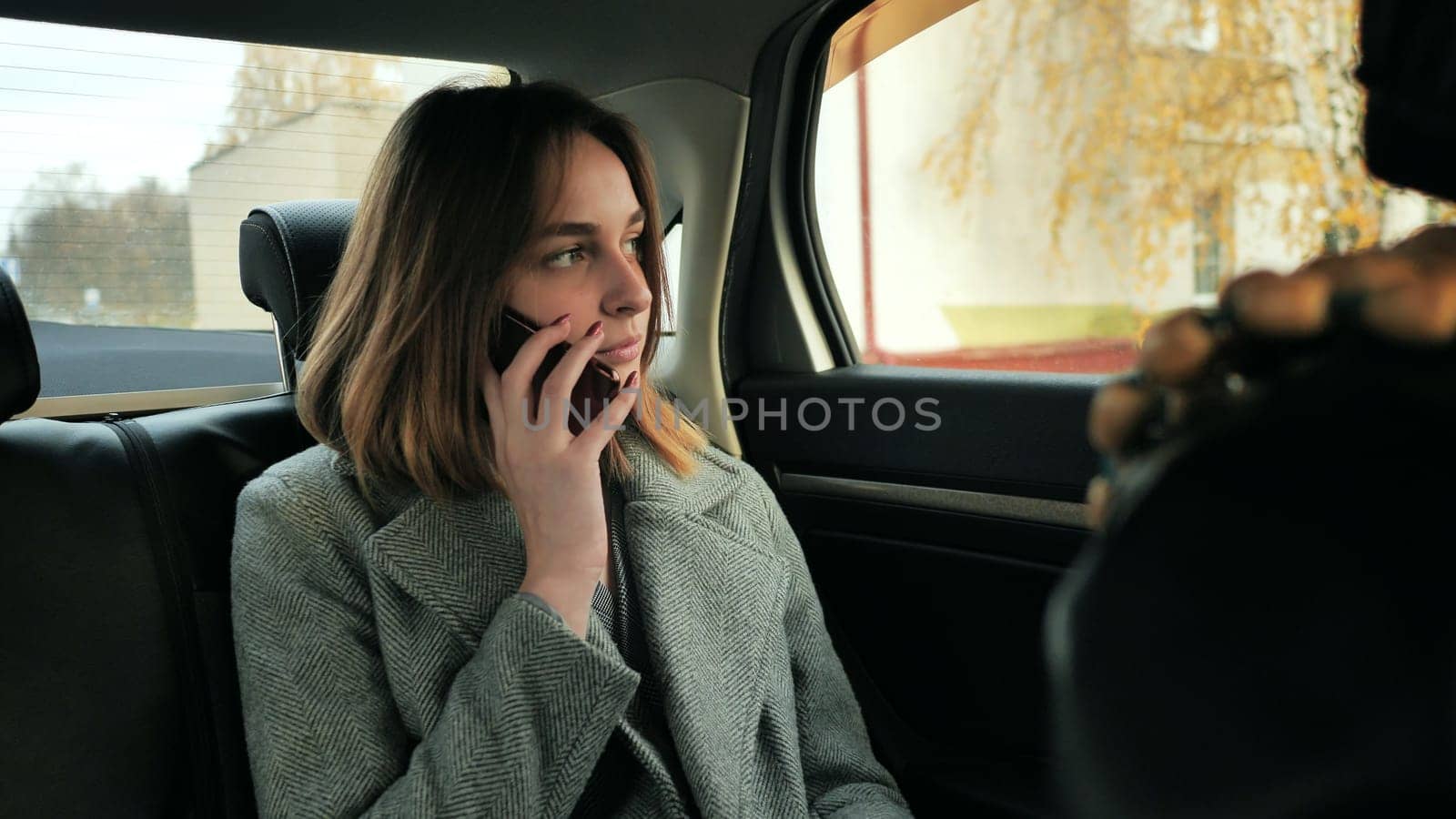 The girl in the car is talking on the phone