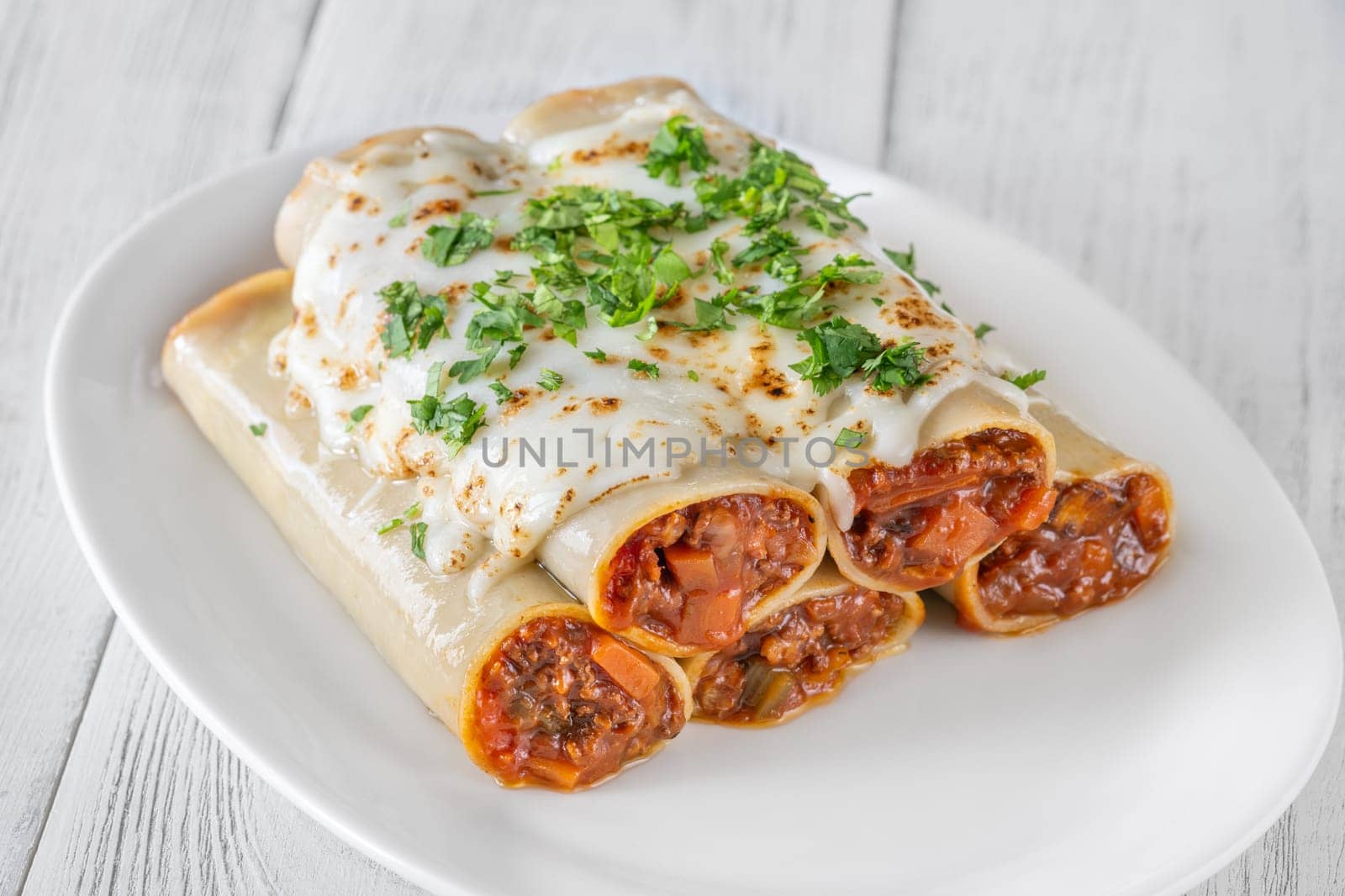 Delicate cannelloni pasta, generously filled with rich bolognese sauce, baked under a blanket of melted mozzarella