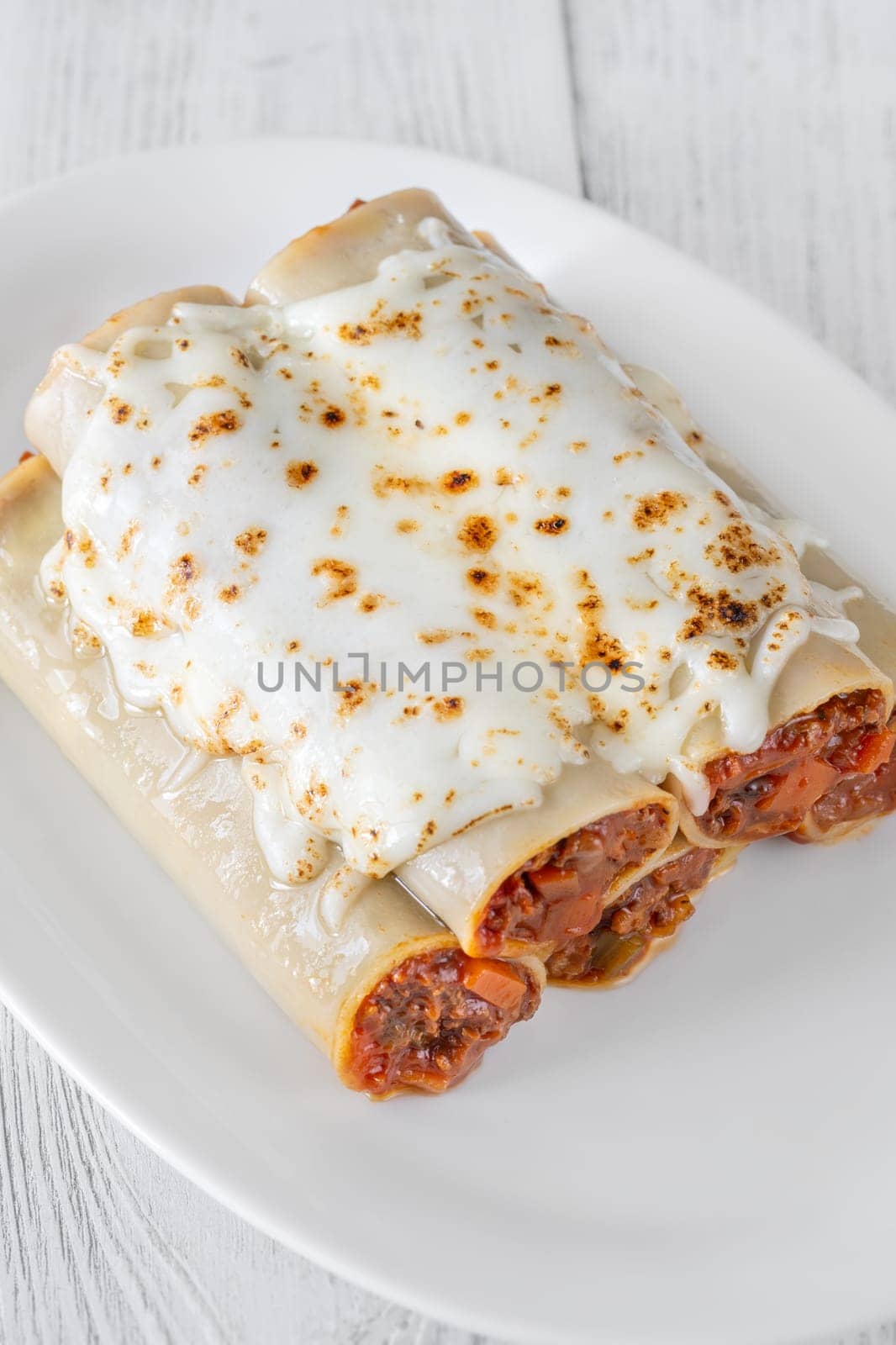 Delicate cannelloni pasta, generously filled with rich bolognese sauce, baked under a blanket of melted mozzarella