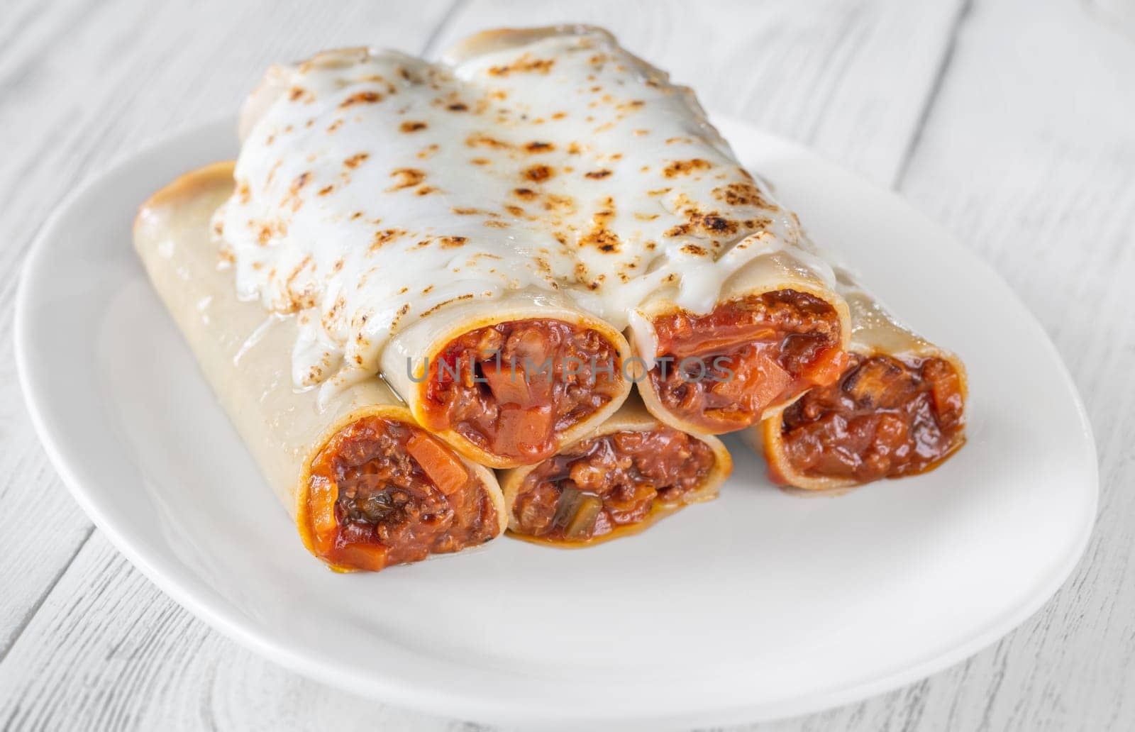 Delicate cannelloni pasta, generously filled with rich bolognese sauce, baked under a blanket of melted mozzarella