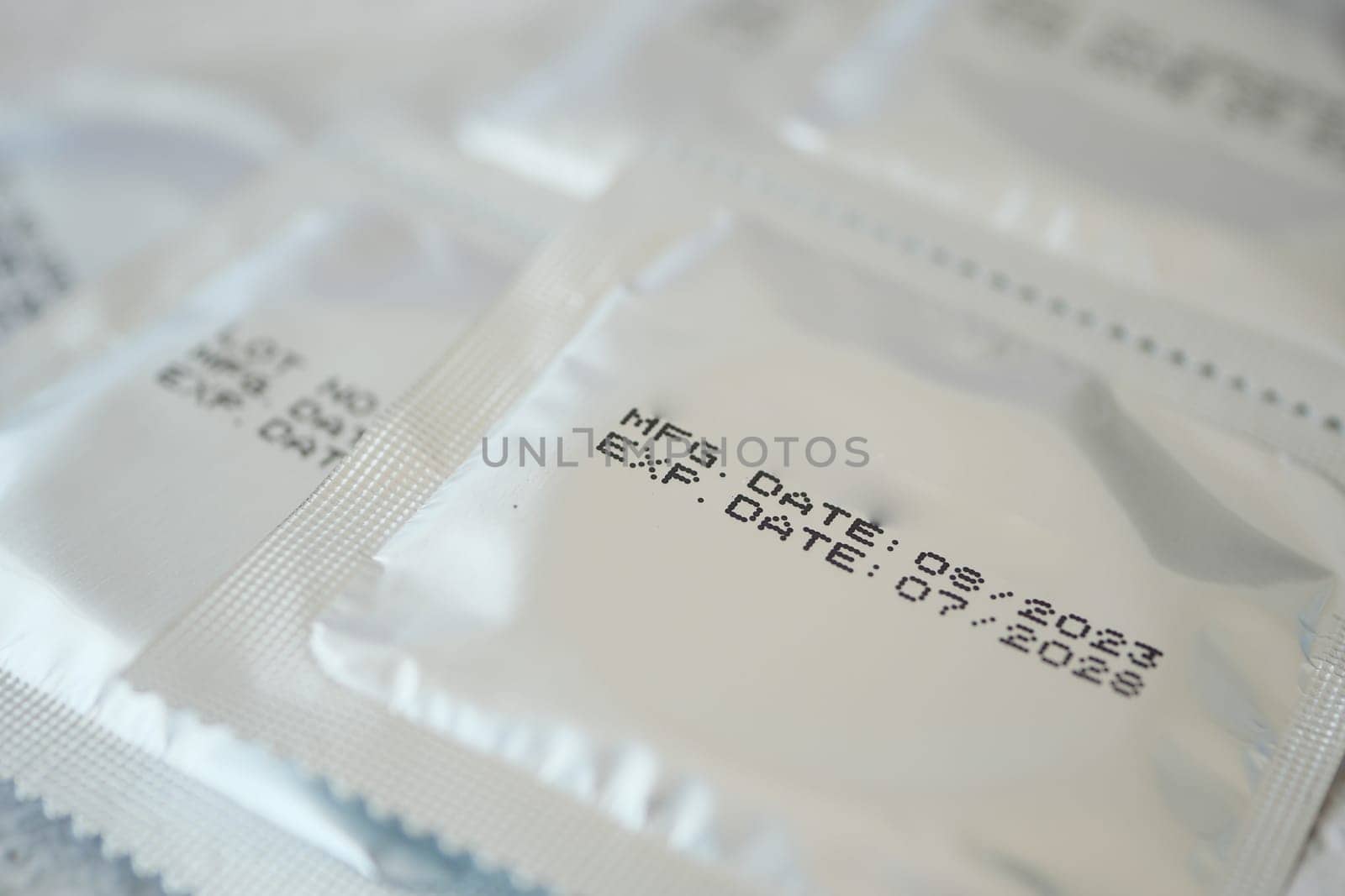 Close-up view of packaged condoms displaying important dates clearly.
