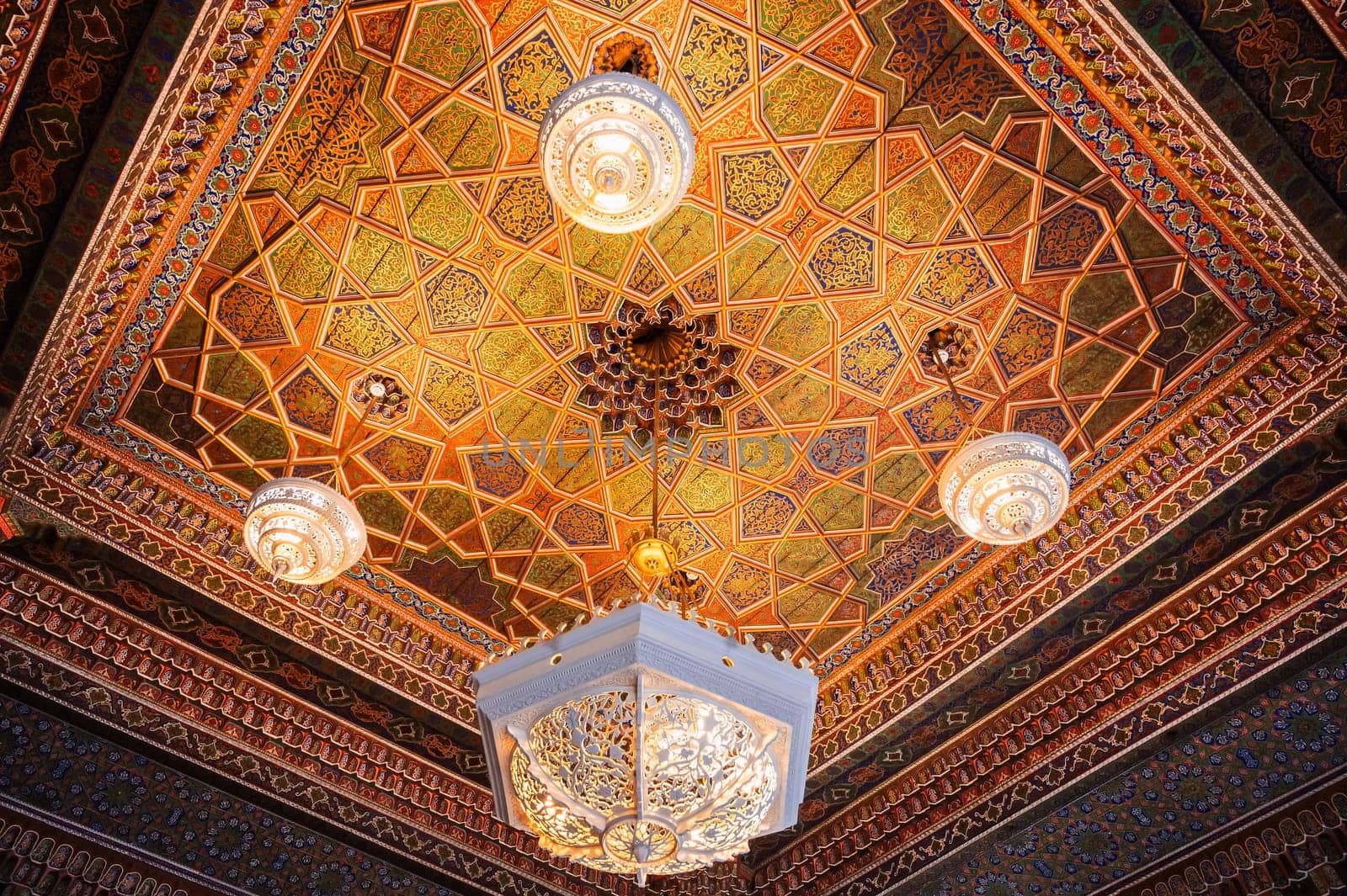 beautiful carved wooden painted ceiling with an ancient chandelier in Museum of Art of Uzbekistan with traditional Uzbek ornaments and oriental patterns in Tashkent