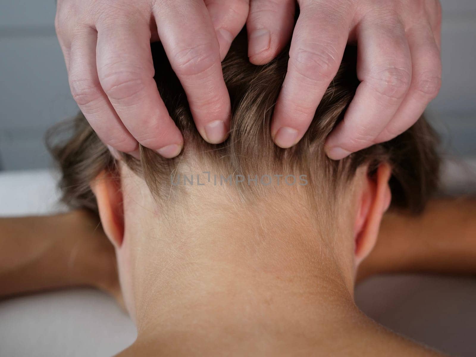 The masseur massages the neck for a woman's client to get rid of pain and discomfort in the body. close-up