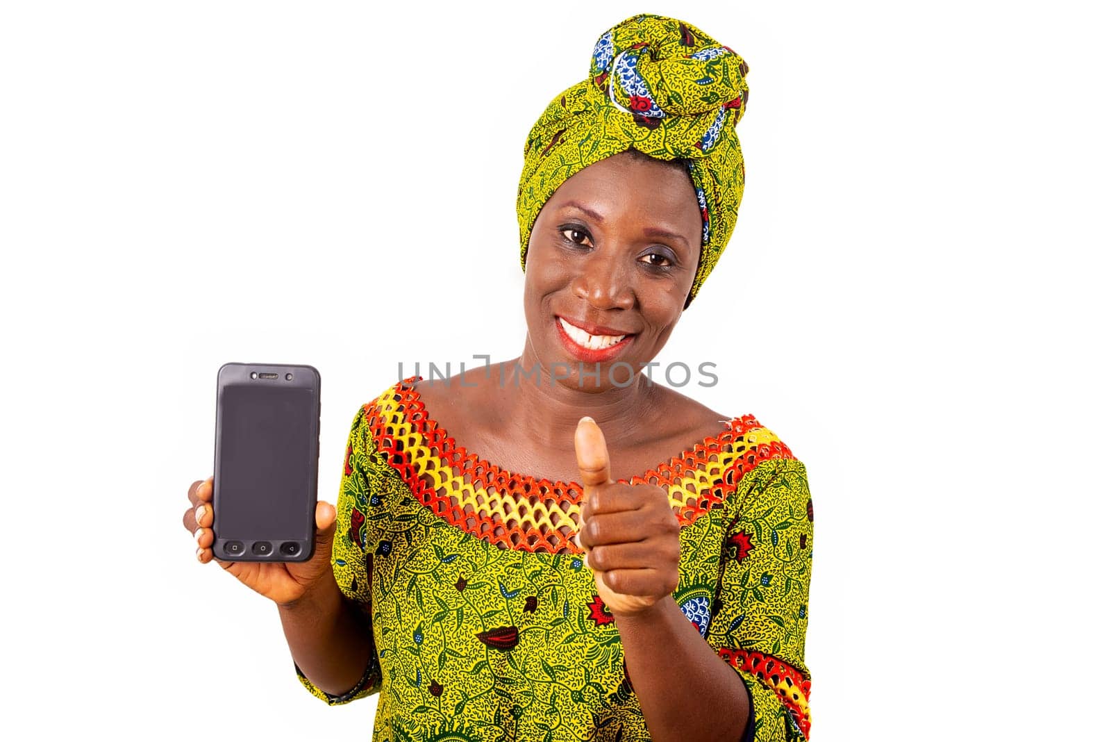 beautiful african adult woman dressed in loincloth and green scarf is happy showing thumbs up with her phone