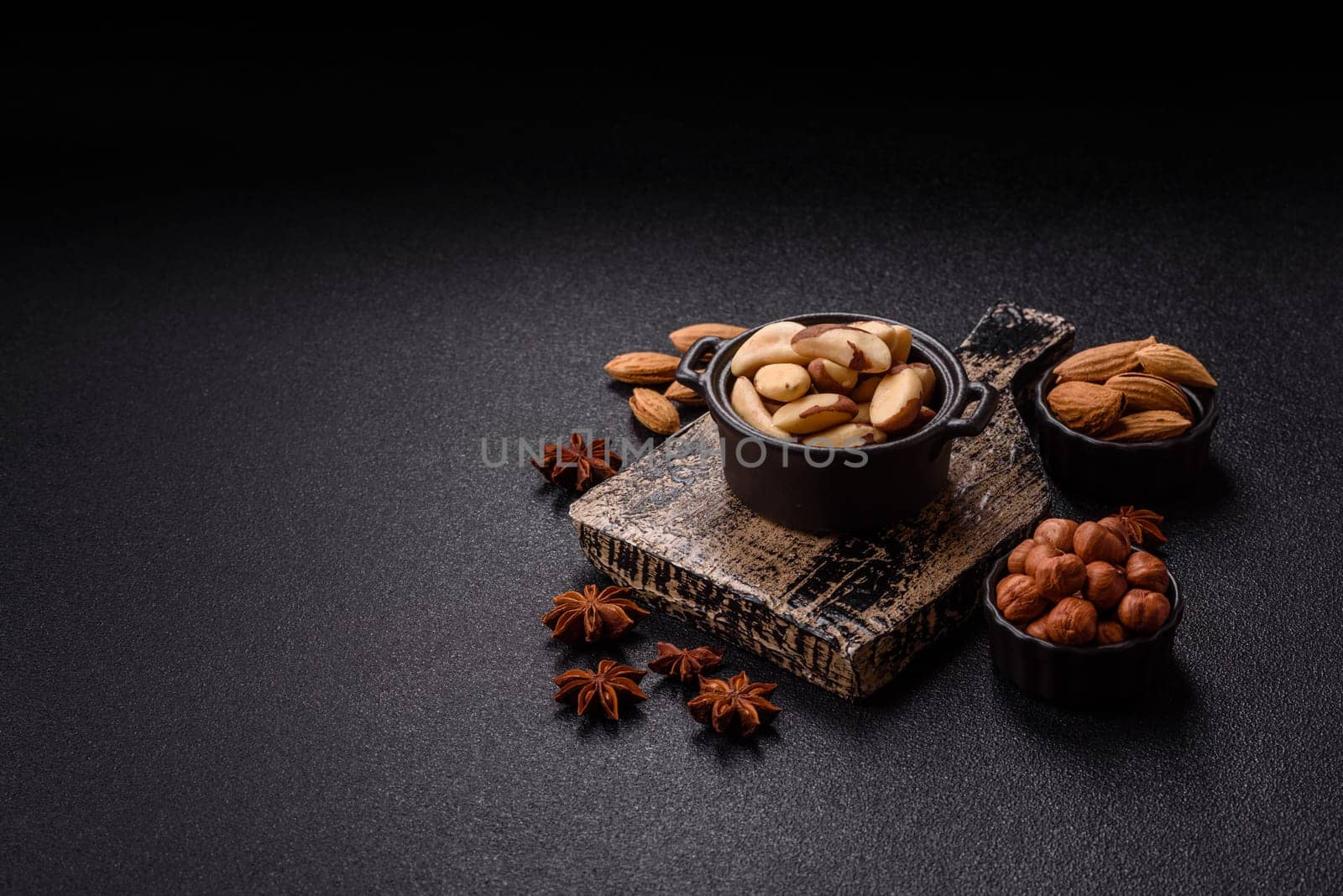 Brazil nut kernels in ceramic bowl on dark concrete background