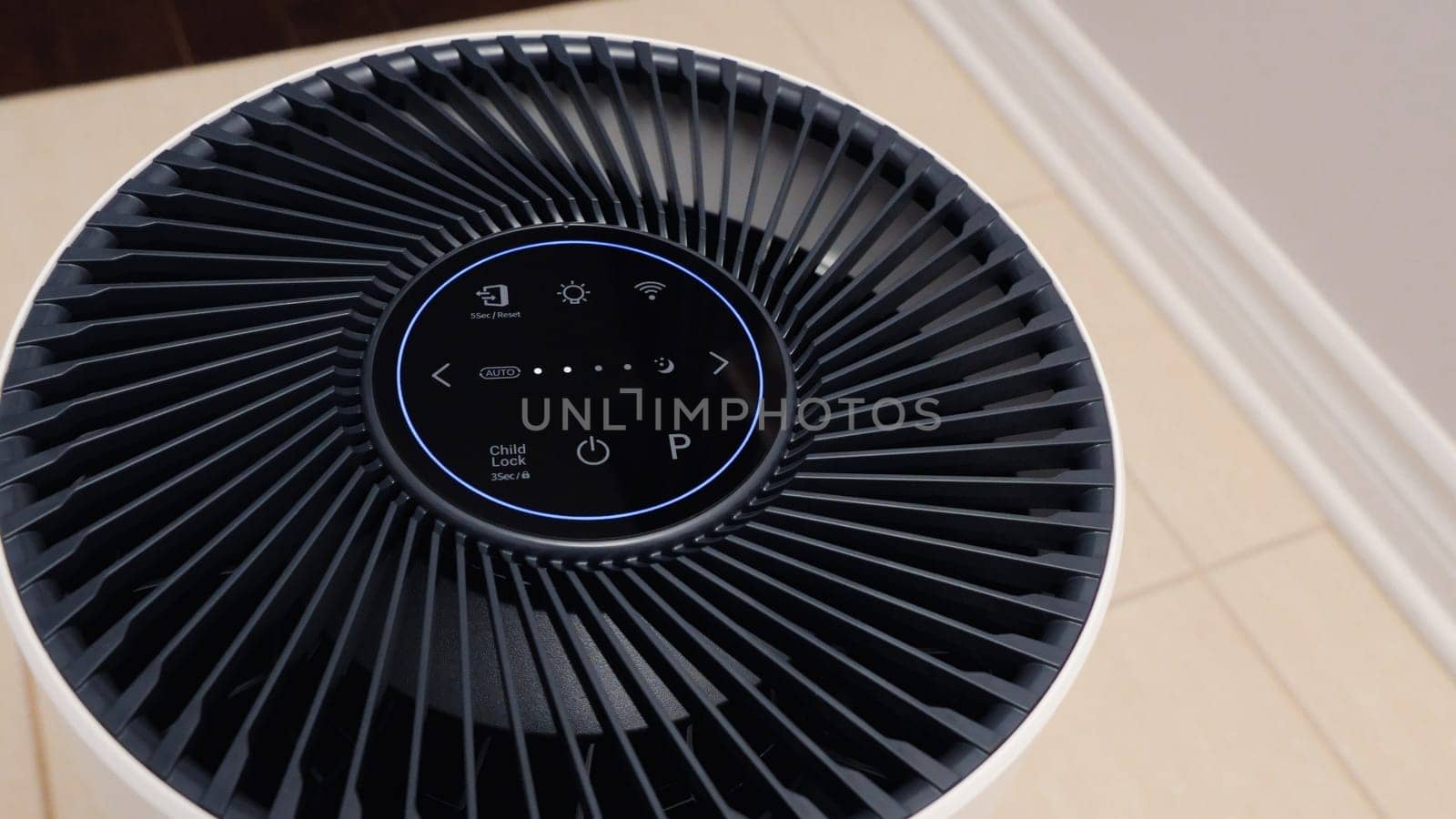Close up view of Air Purifier with Black Fan. Black Round Electronic Device with Buttons and Bright Lights on White Background.