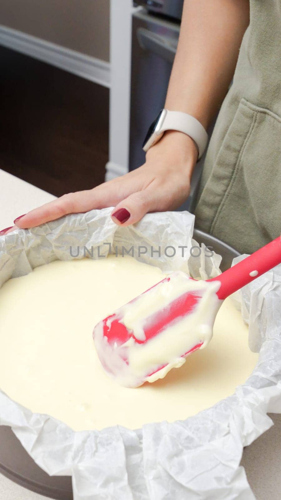 Deliciously Smooth Cake Batter Being Mixed with a Red Spatula in a Black Round Cake Pan.
