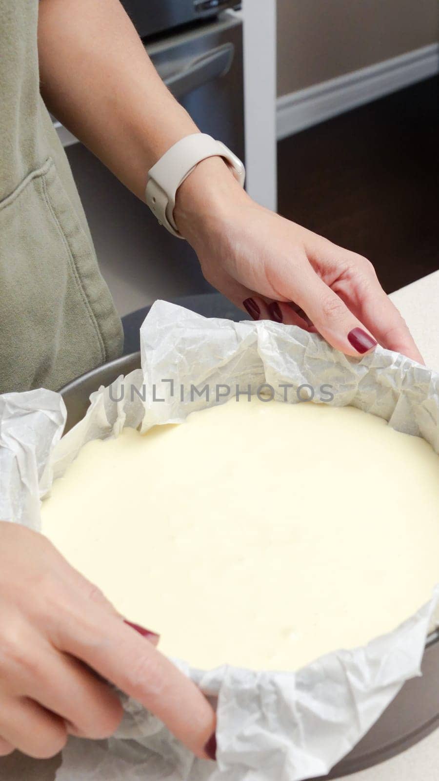 Female hand holding a cake pan with a delicious homemade cheesecake.