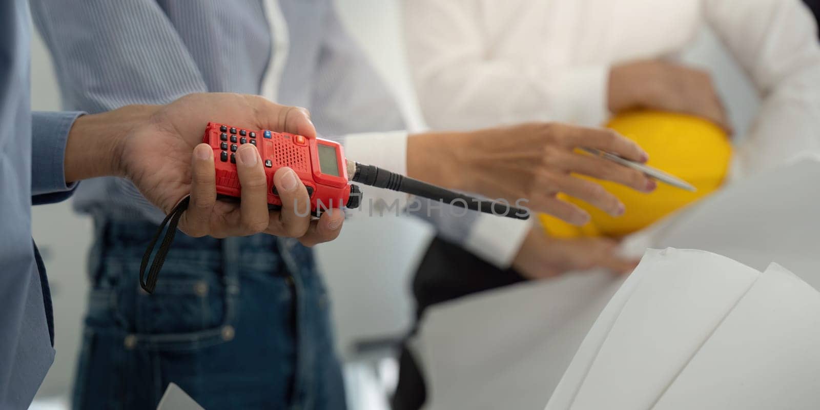 Construction professionals utilize modern tools and effective communication devices to enhance their project discussions, focusing on precision and strategy in a collaborative environment.