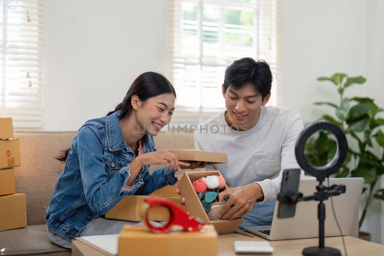 A cheerful moment as both entrepreneurs unbox their new inventory filled with handmade items, radiating joy and enthusiasm for their business.