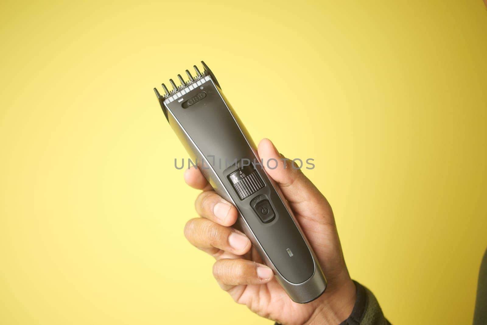 Individual displays a hair clipper with a smooth grip and adjustable settings.