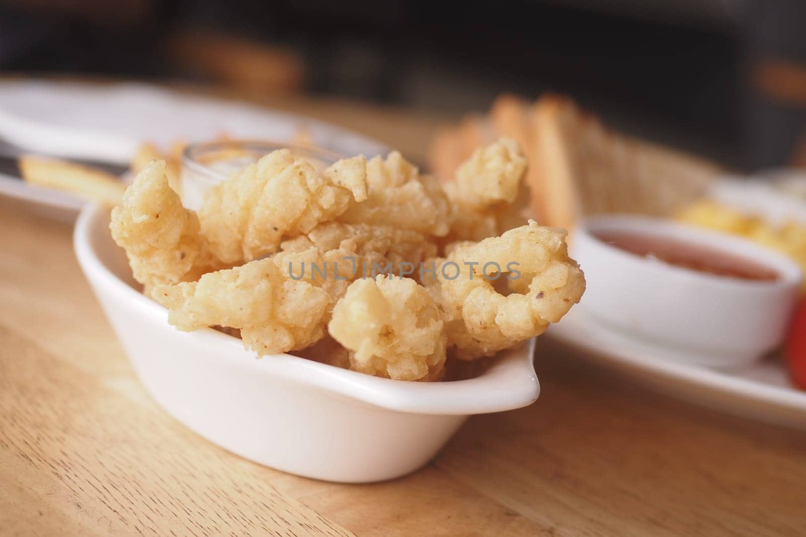 Enjoying crispy fried calamari with tangy dipping sauce at lunch.