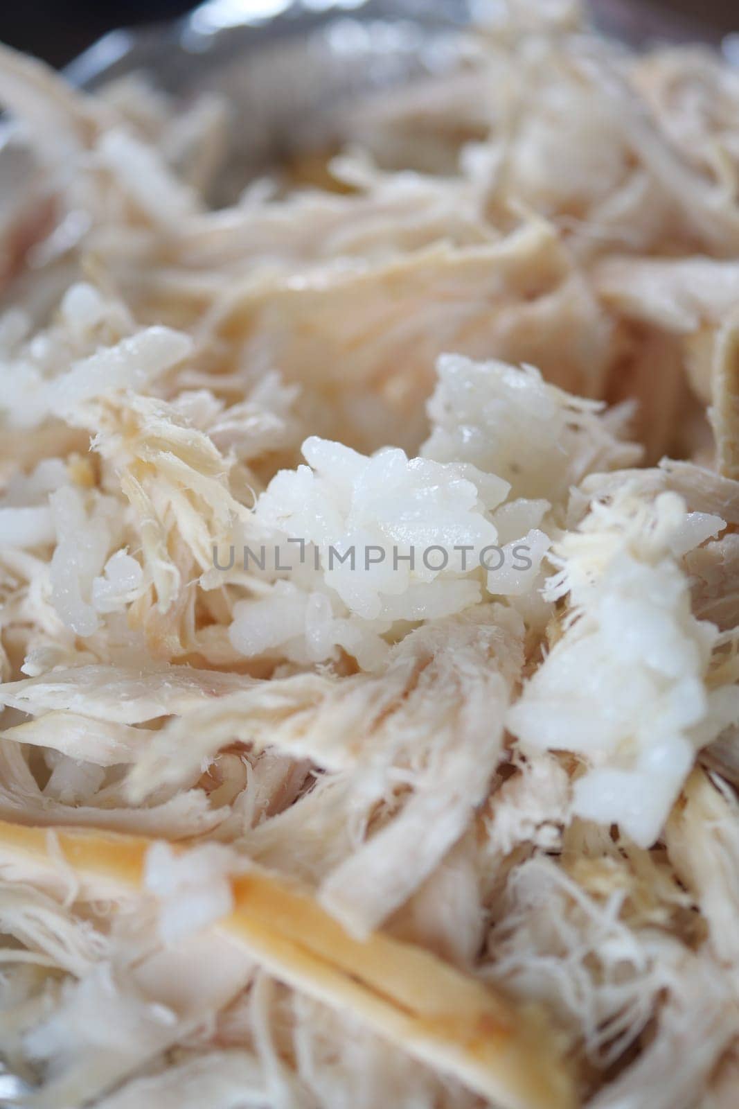 Tender shreds of chicken mixed with fluffy rice are served together.