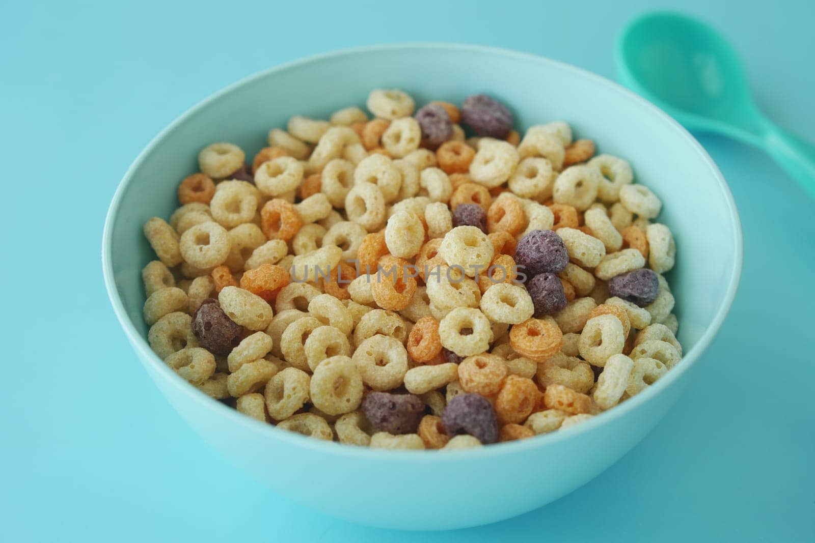 A bowl filled with assorted colorful cereal pieces ready to eat.