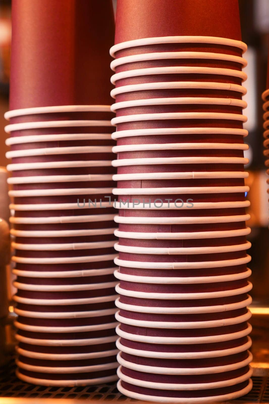 Stacks of disposable cups prepare for a busy coffee service at a cafe.