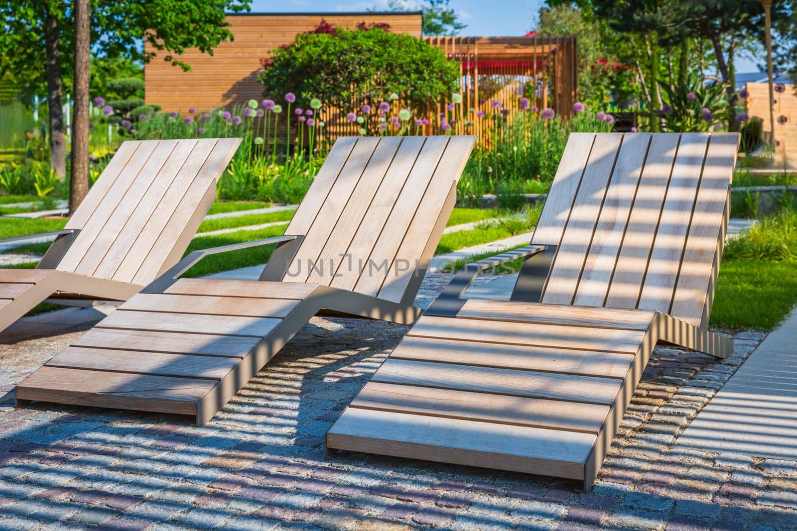 Modern wooden deck chairs or chaise longues for patio or garden