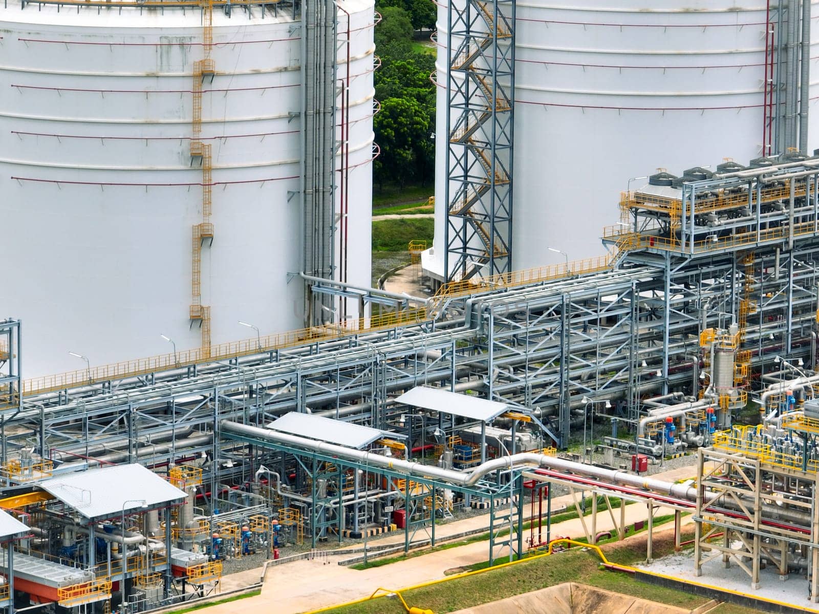Industrial oil refinery with complex network of steel pipelines and massive storage tanks. Petrochemical plant producing fuel energy. Modern industrial infrastructure for petroleum processing.