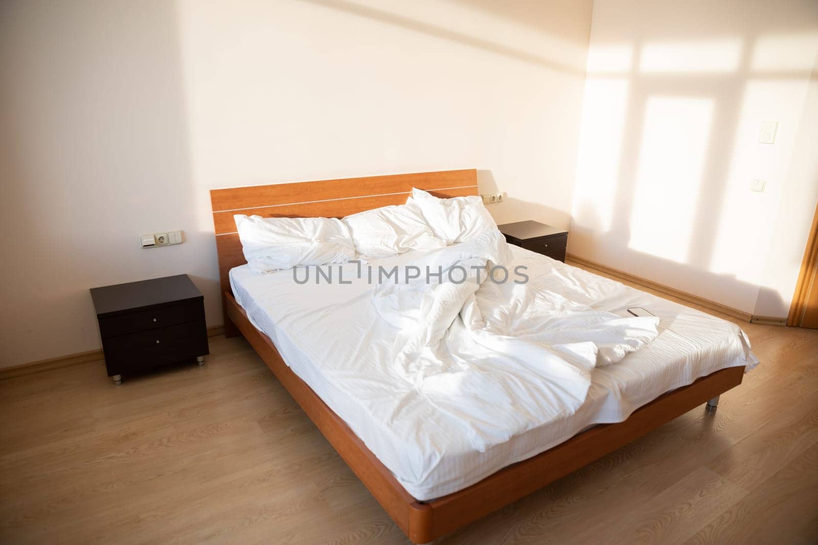 Empty bed with linen in the bedroom in the morning