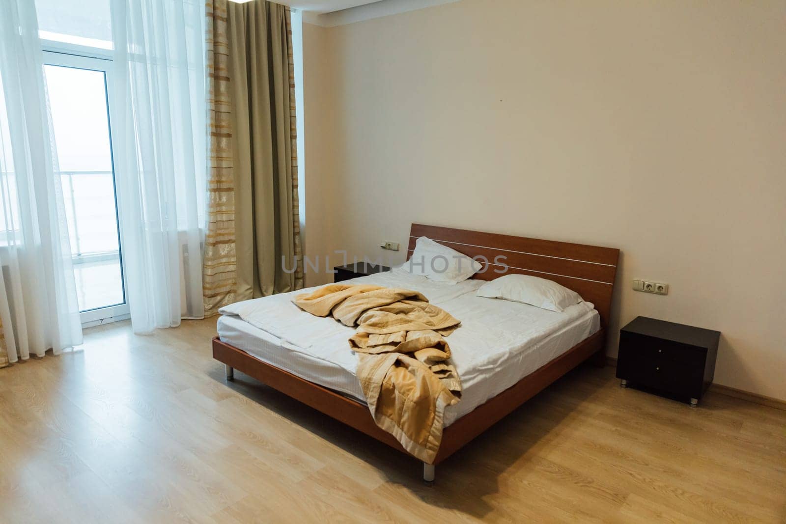 Empty bed with linen in the bedroom in the morning