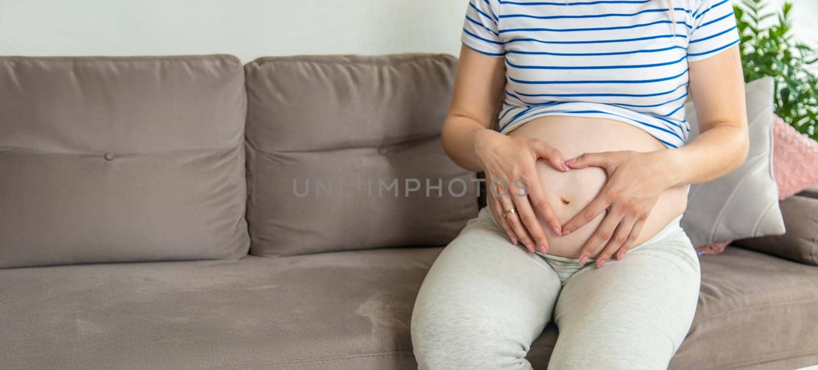 Pregnant woman hands heart belly. Selective focus. Love.
