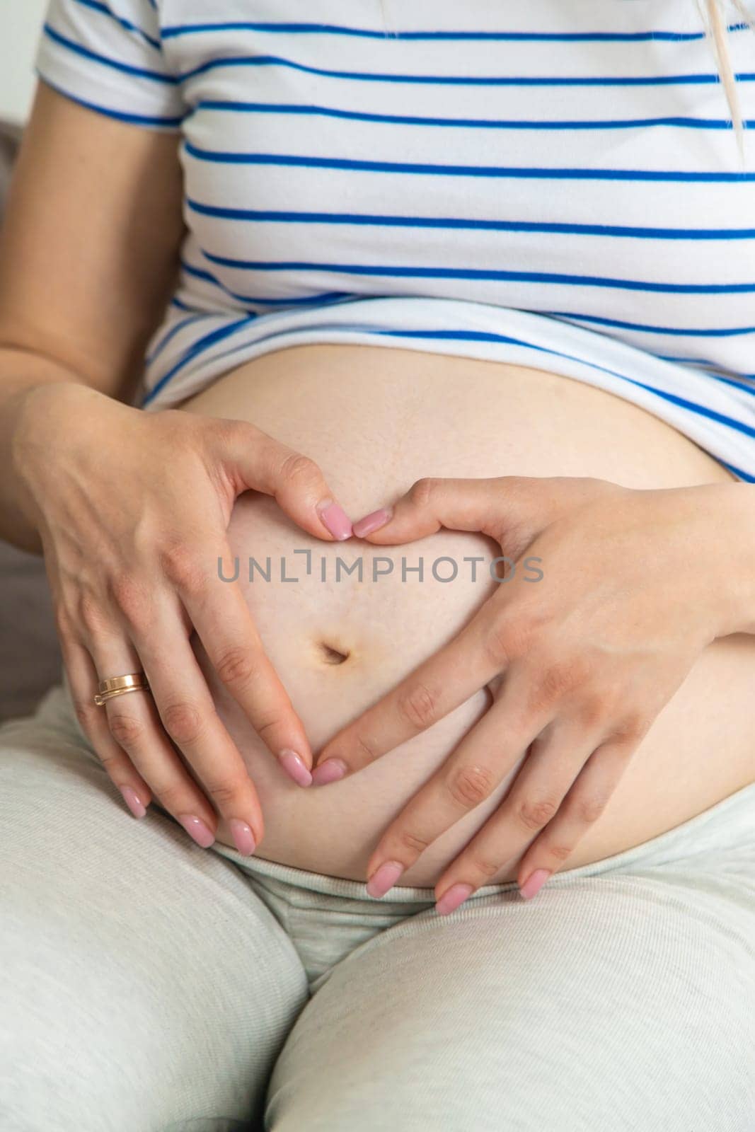 Pregnant woman hands heart belly. Selective focus. Love.