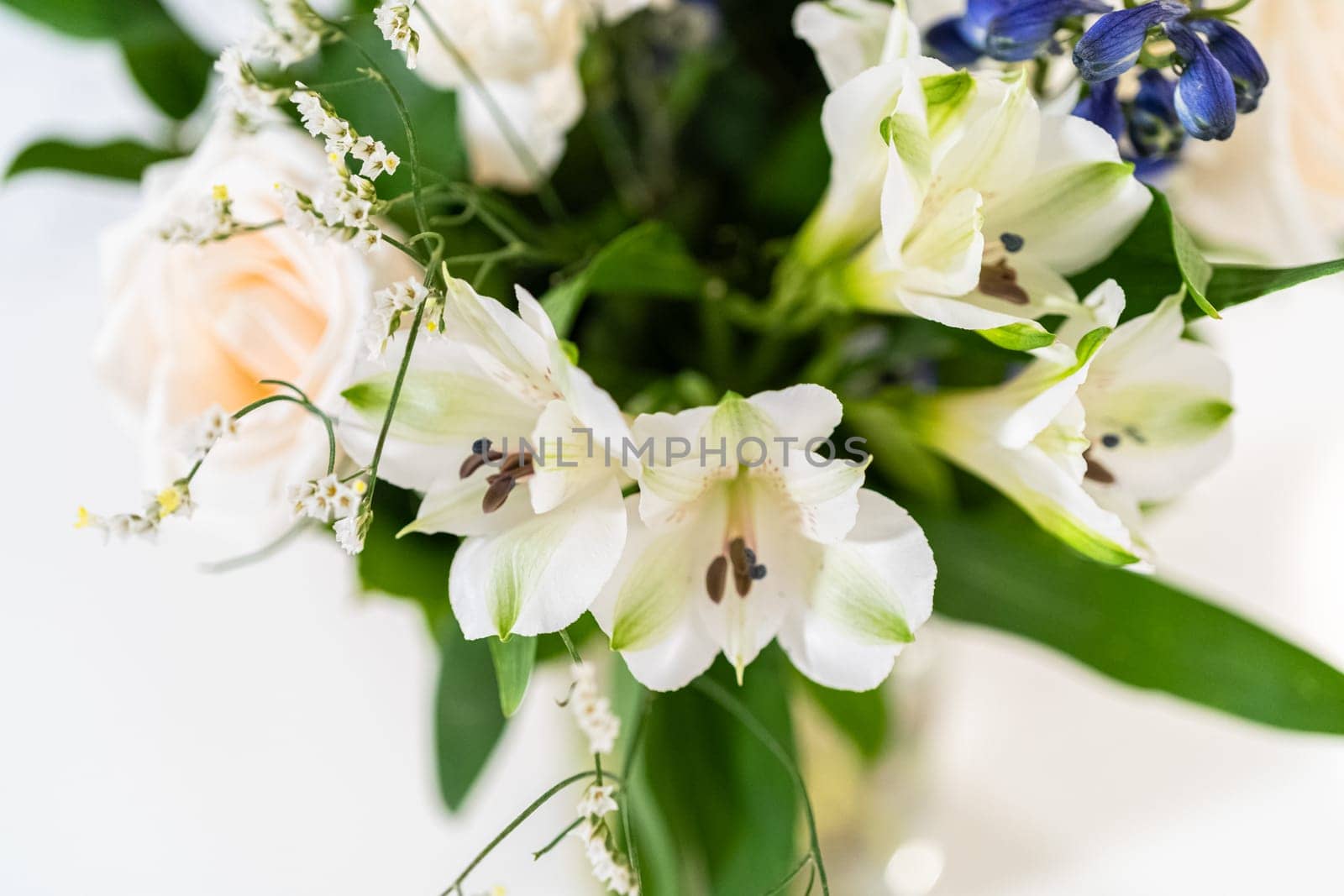 A stunning bouquet featuring fresh white roses and assorted flowers gracefully arranged in a vase, exuding timeless beauty.
