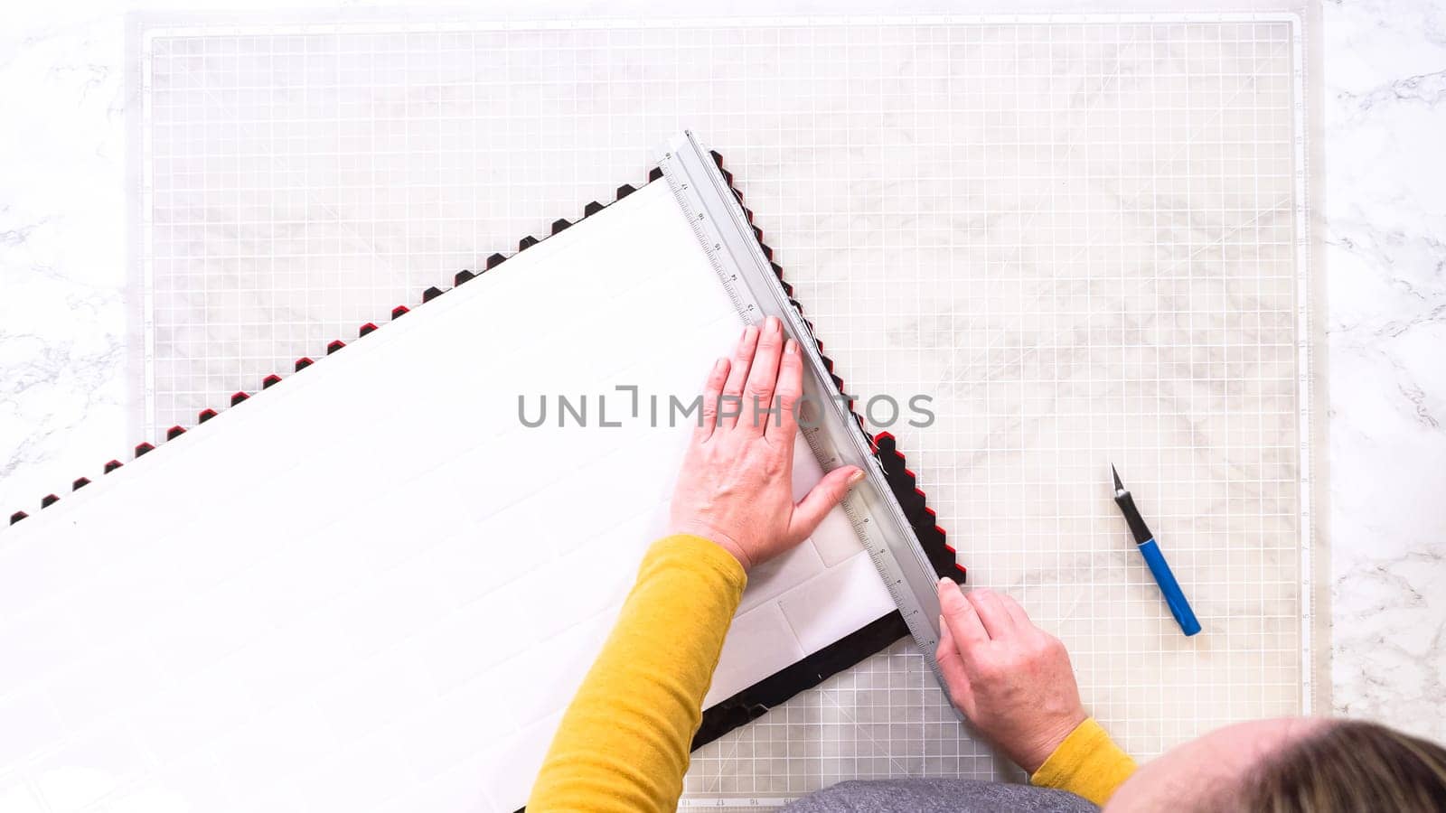 Flat lay. In the process of mounting peel and stick mosaic tiles onto a foam board, perfect for enhancing a food photography studio's aesthetic.