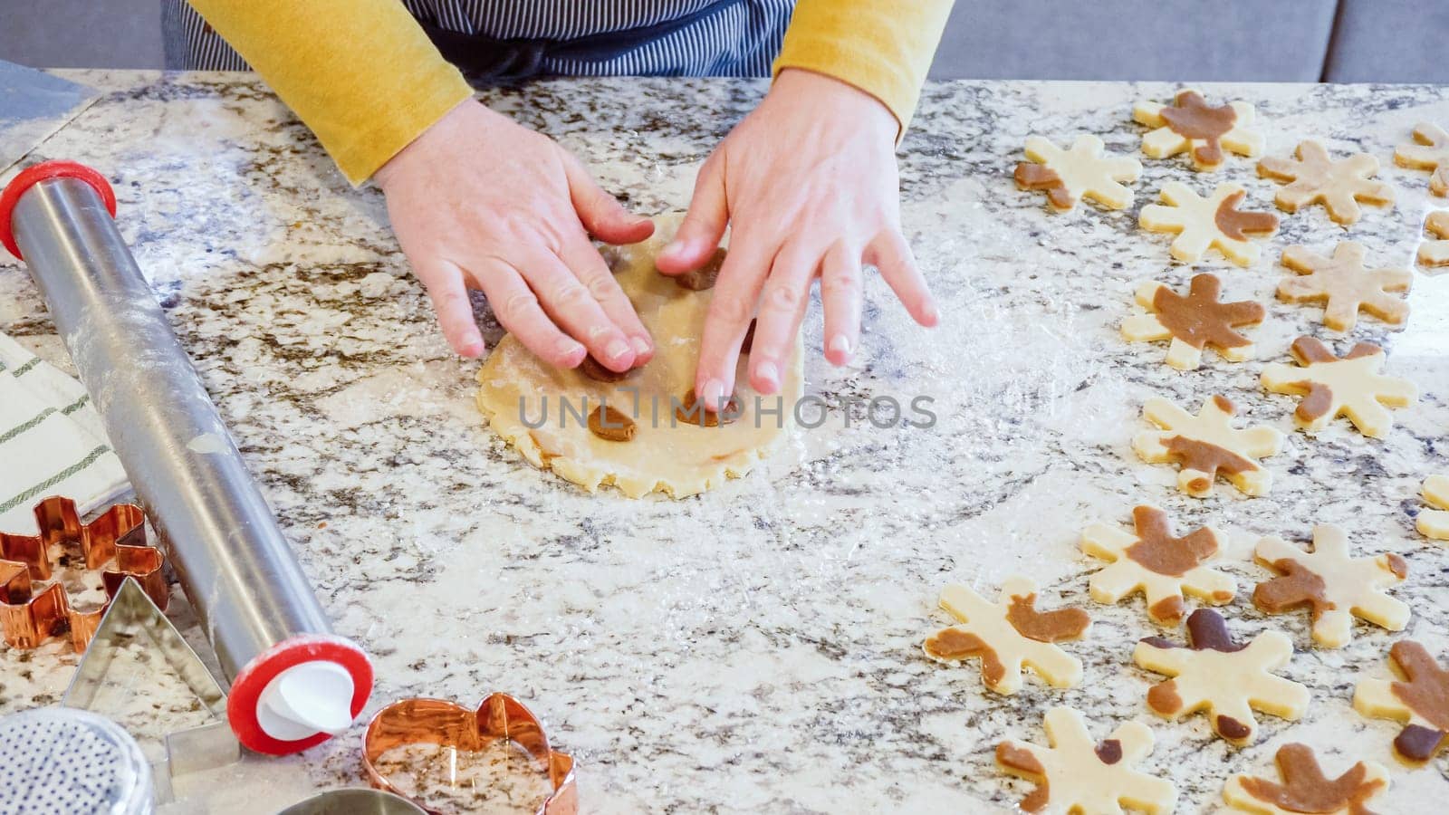 Using an adjustable rolling pin to roll out gingerbread cookie dough on the elegant marble counter in a modern kitchen, getting ready for festive holiday baking.