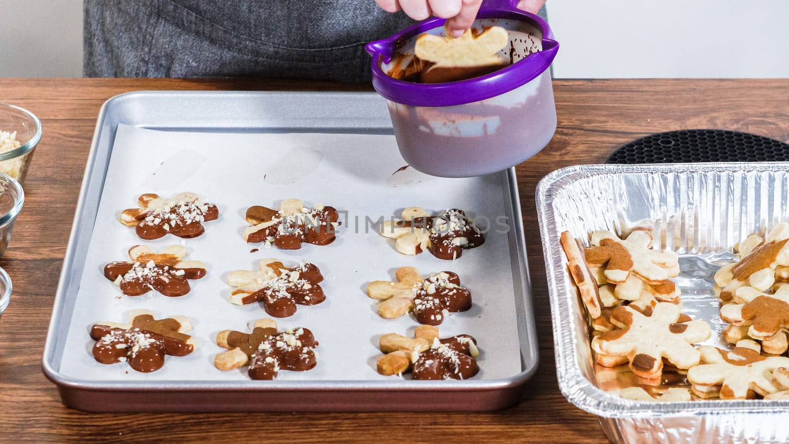 Crafting star-shaped holiday cookies dipped in chocolate and sprinkled with variety of toppings.