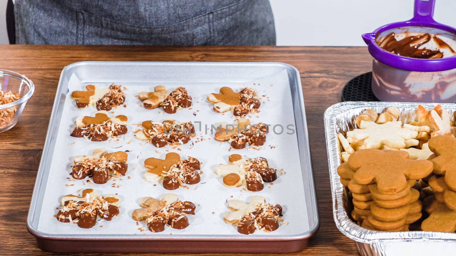 Carefully packaging Christmas cutout cookies, half-dipped in chocolate and presented in clear cellophane wrapping, perfect for festive gifting.