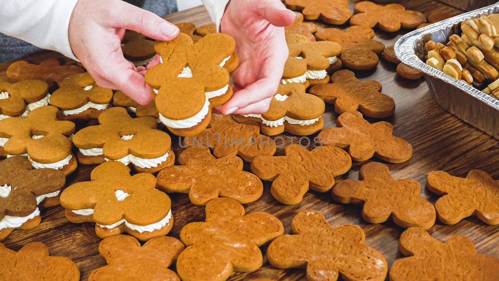 Crafting gingerbread cookie sandwiches with eggnog buttercream, presented on a rustic wooden table for Christmas gifting.