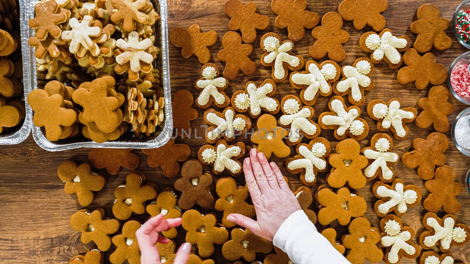Flat lay. Crafting gingerbread cookie sandwiches with eggnog buttercream, presented on a rustic wooden table for Christmas gifting.