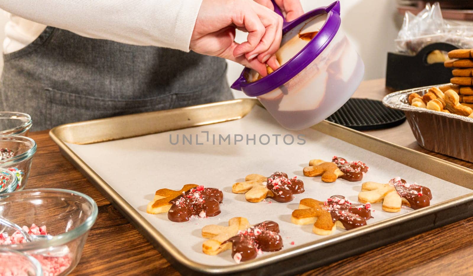 Preparing star-shaped cookies, half-dipped in chocolate, accented with peppermint chocolate chips for the holidays.