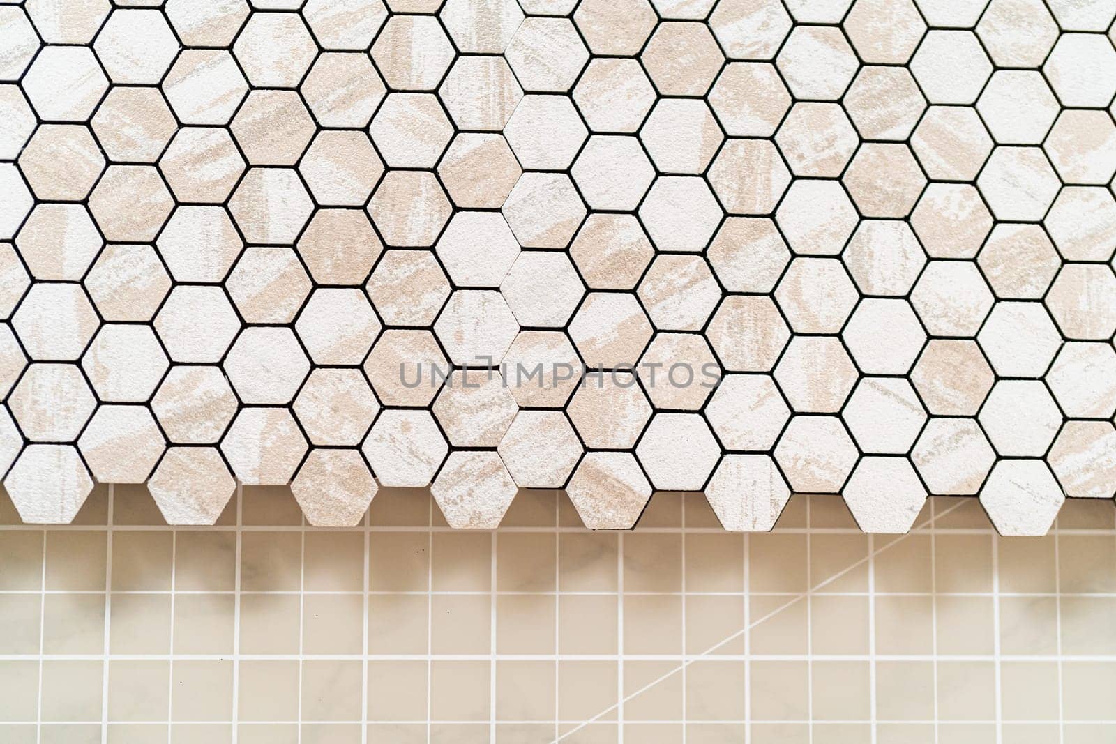 In the process of mounting peel and stick mosaic tiles onto a foam board, perfect for enhancing a food photography studio's aesthetic.