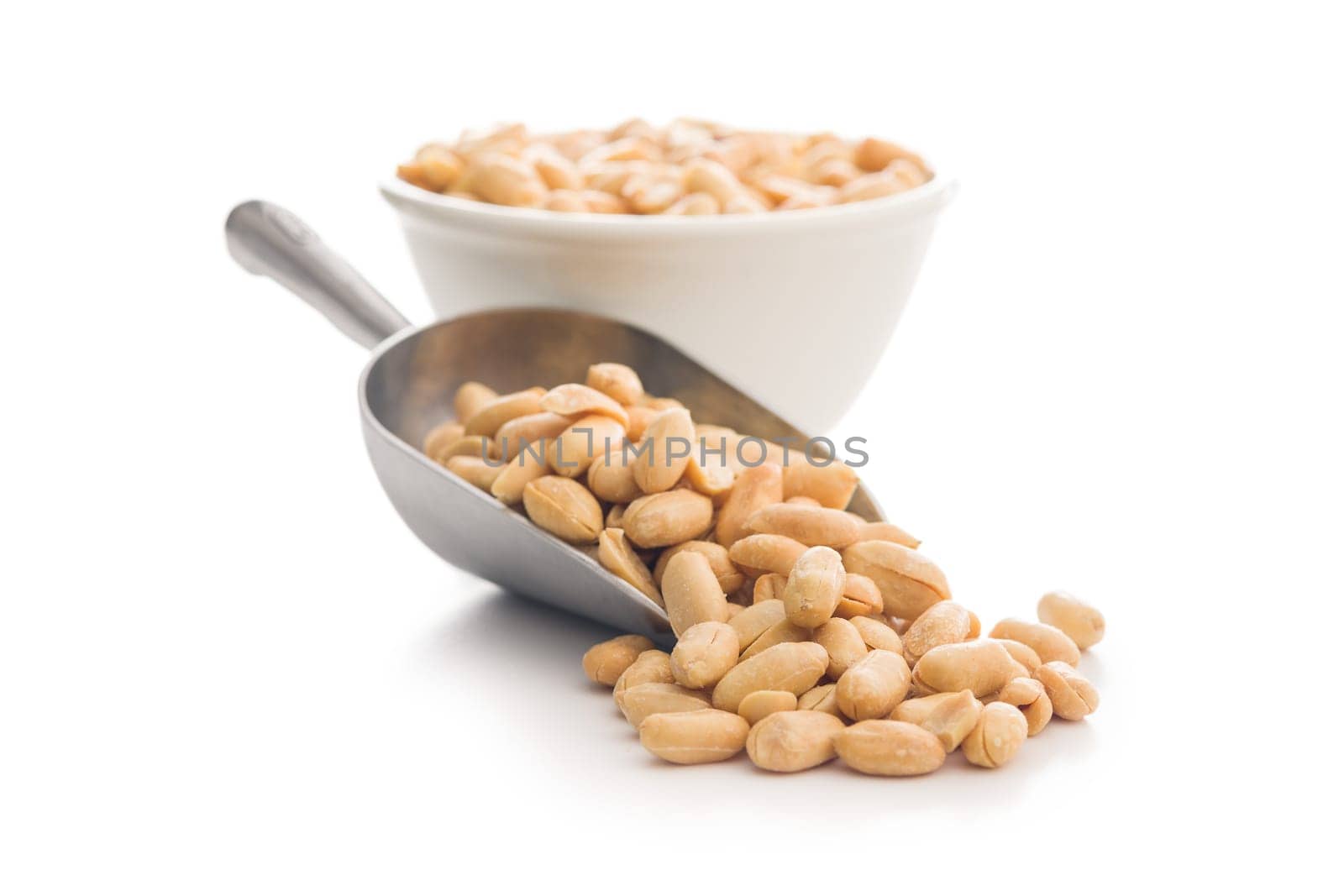 Roasted salted peanuts in scoop isolated on a white background.